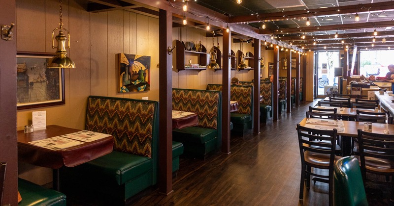 Interior, inline restaurant booths and lined up dining tables with chairs