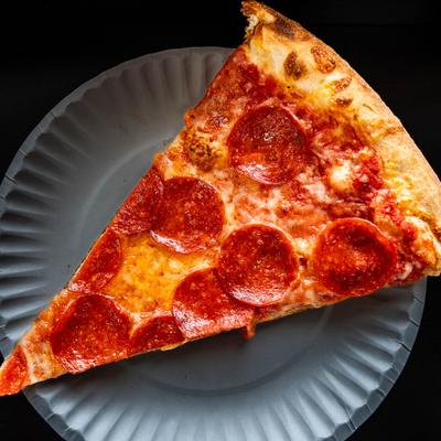 A slice of pepperoni pizza on a plate, top view.