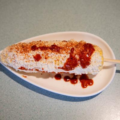 Mexican street corn slathered with mayonnaise, cotija cheese and chili powder.