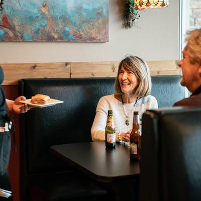A couple of guests interacting with a waitperson.