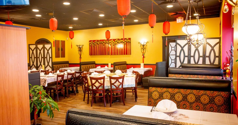 Interior, dining area, tables with chairs, padded seating booths, various decoration