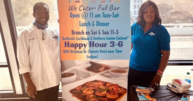 Employees next to restaurant banner