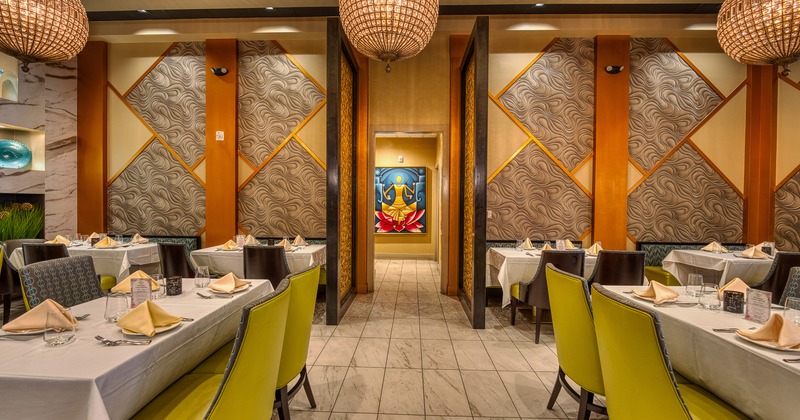 Interior of cozy and stylish dining area with dining tables set for guests