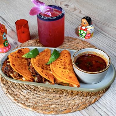 Birria tacos with broth.