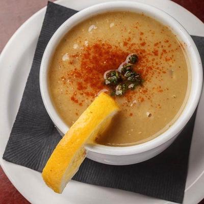 Soup served with a slice of lemon