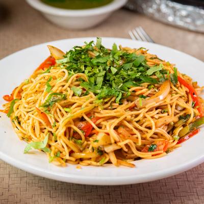 Vegetable Hakka Noodles topped with fresh herbs.