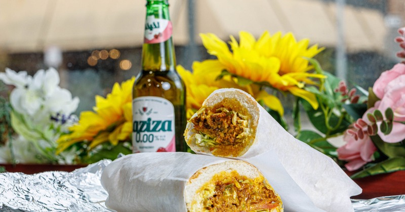 Steak Sub sandwich served with a bottle of beer