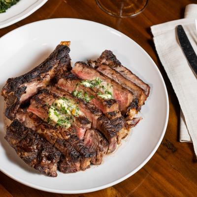 Bone In Cowboy Ribeye served on the table.