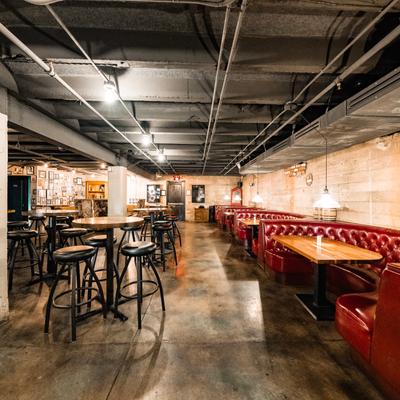 Interior, seating area, tables with bar stools and round booths.