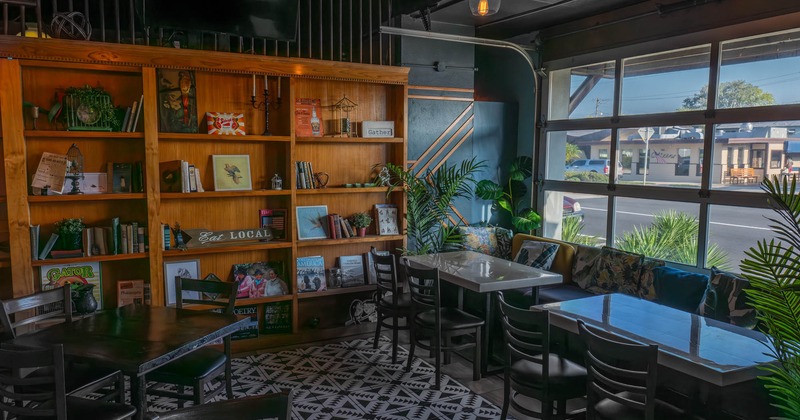 Interior, banquette bench with tables, large wooden bookshelf, large shop window