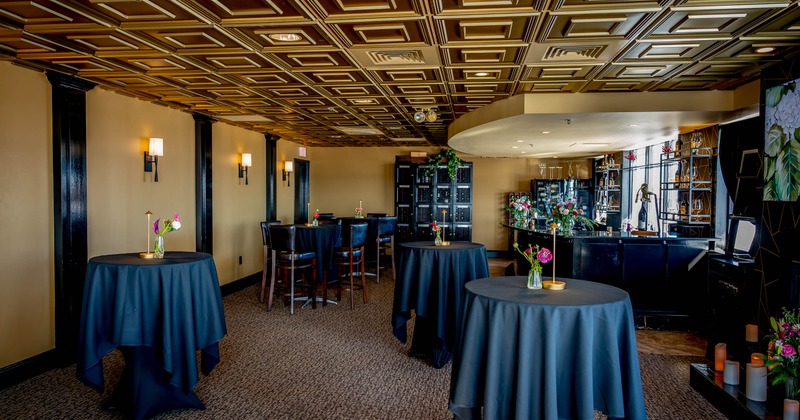 Elegantly decorated interior - coffered ceiling, high tables, floral centerpieces and a bar counter