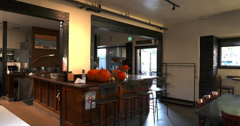 Interior of a cafe with a wooden counter decorated with pumpkins and flowers