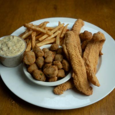 Fried catfish with fries, hushpuppies. and dipping sauce.
