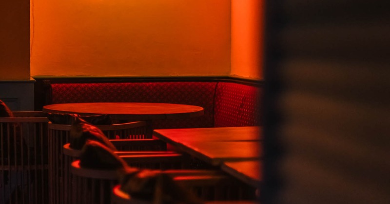 Interior, tables and chairs with neon sign on the wall