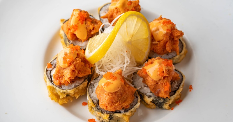 Fried sushi rolls with spicy tuna and lemon garnish
