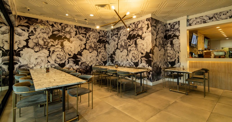 Interior, dining area, long table setups for twelve and ten people, floral design wallpapers