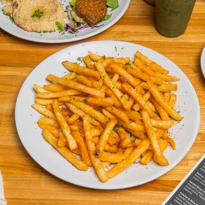 Seasoned fries served on a white plate.