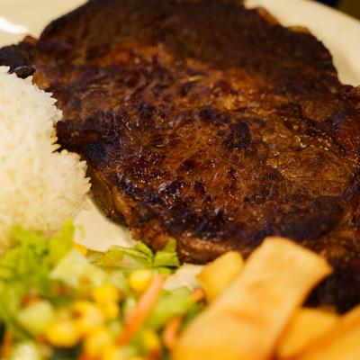 Grilled ribeye steak, rice and salad, closeup.