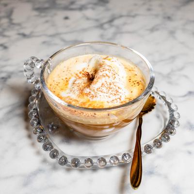 A glass cup of Affogato served on a glass saucer.