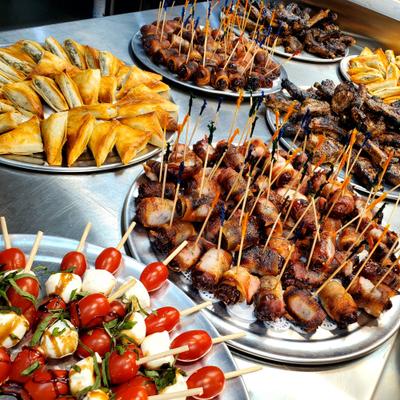 Assortment of bite-sized finger foods and appetizers served on skewers.