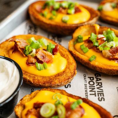 Loaded potato skins topped with melted cheese, bacon bits, and scallions.