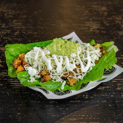 Chicken taco in a lettuce wrap.