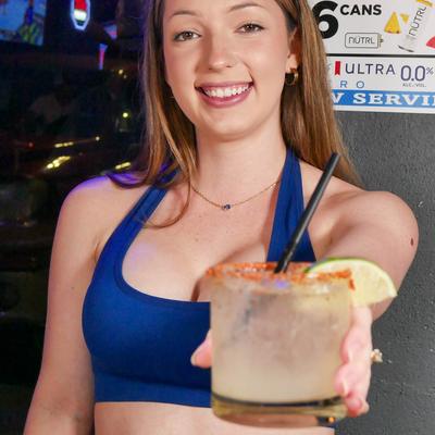 A person presenting a cocktail on the rocks.