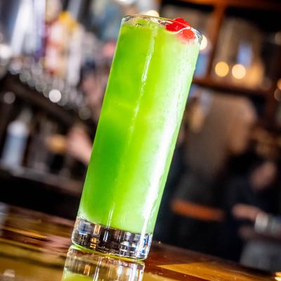 Liquid Marijuana cocktail on a bar counter, decorated with a red cherry.