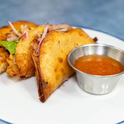 Three crispy tacos filled with shrimp, potato, lettuce, and onions, served with seafood broth.