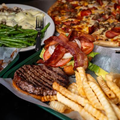 Burger with bacon, lettuce, tomato, onions, and fries.