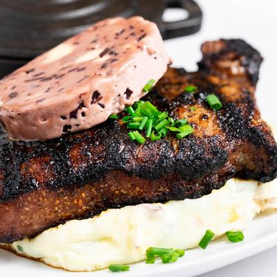 Grilled New York Strip steak, with mash and sausage, closeup