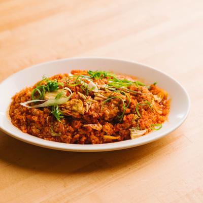 Fried rice topped with herbs on a plate.
