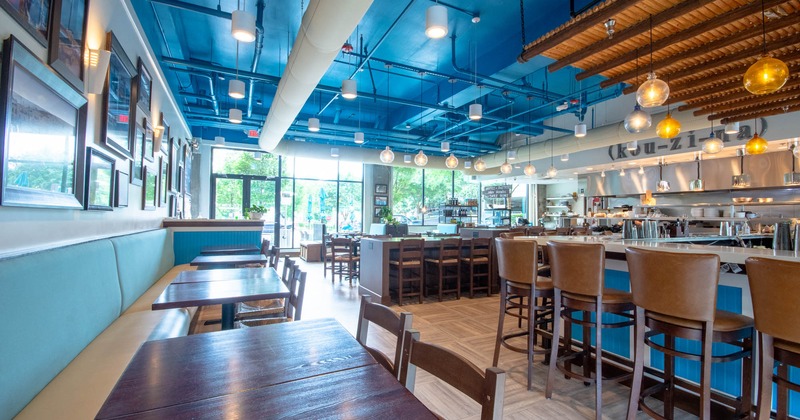 Interior, wall banquet seating with tables and chairs, bar area