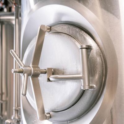 Round metal hatch on brewing equipment.