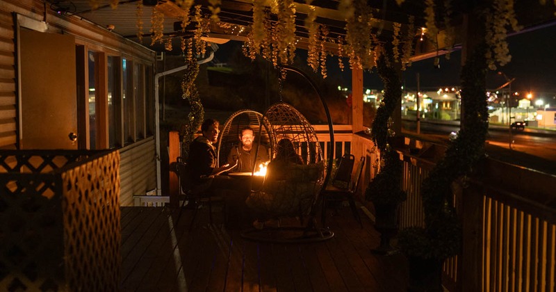 Exterior, patio, guests sitting and chatting, candle on the table