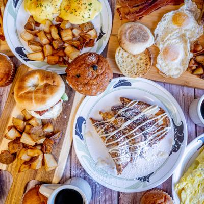Various breakfast dishes served on the table with couple cups of coffee.