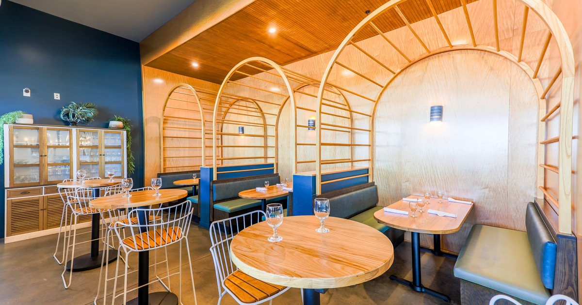 Interior, seating area with tables, chairs, booth seating, and arched dividers