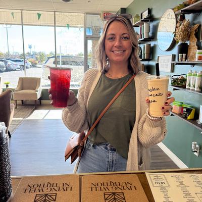 Person holding two drinks at the bar counter.