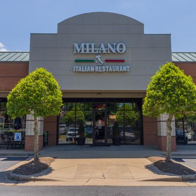 Restaurant front entrance with two trees planted on the sidewalk.