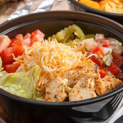 Grilled chicken salad, with shredded cheese, and mixed vegetables.