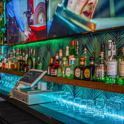 Back bar, liquor, glasses and TV screens.
