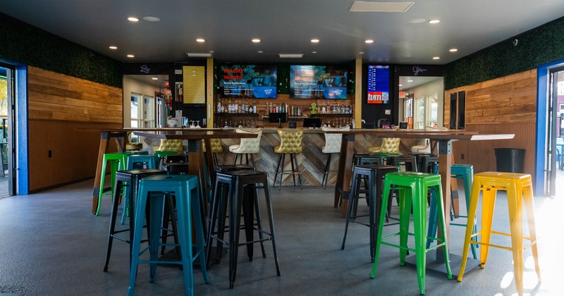 Interior, high tables and chairs with bar in the back