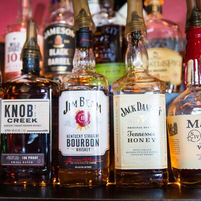 4 bottles with Knob Creek, Jim Beam Tennessee Bourbon, Jack Daniels Sweet Honey and Maker's Mark bourbon blend