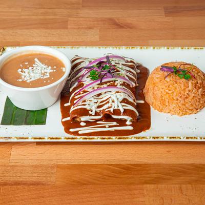 Enchiladas smothered in red sauce, served with rice and beans.