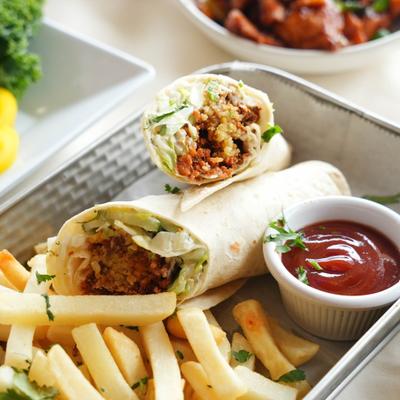 Falafel Wrap served with fries and a dipping sauce.