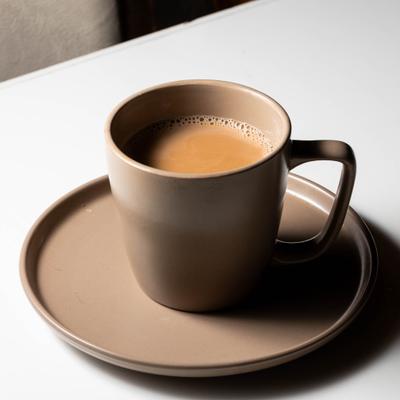 A cup of masala chai placed on a saucer.