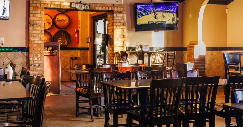 Interior, tables and chairs near the entrance door, TV on the wall