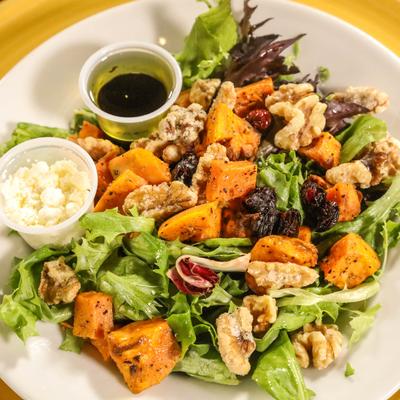 Salad with lettuce, sweet potatoes, walnuts, feta, cranberries, and vinaigrette.