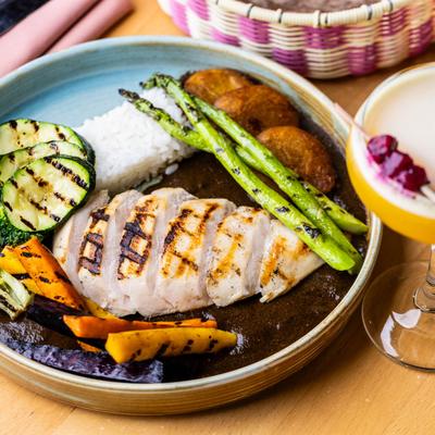 Grilled chicken breast with rice, roasted vegetables, zucchini, asparagus, and potatoes.