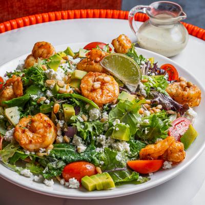 Bowl of Mediterranean Shrimp Salad with dressing on the side.